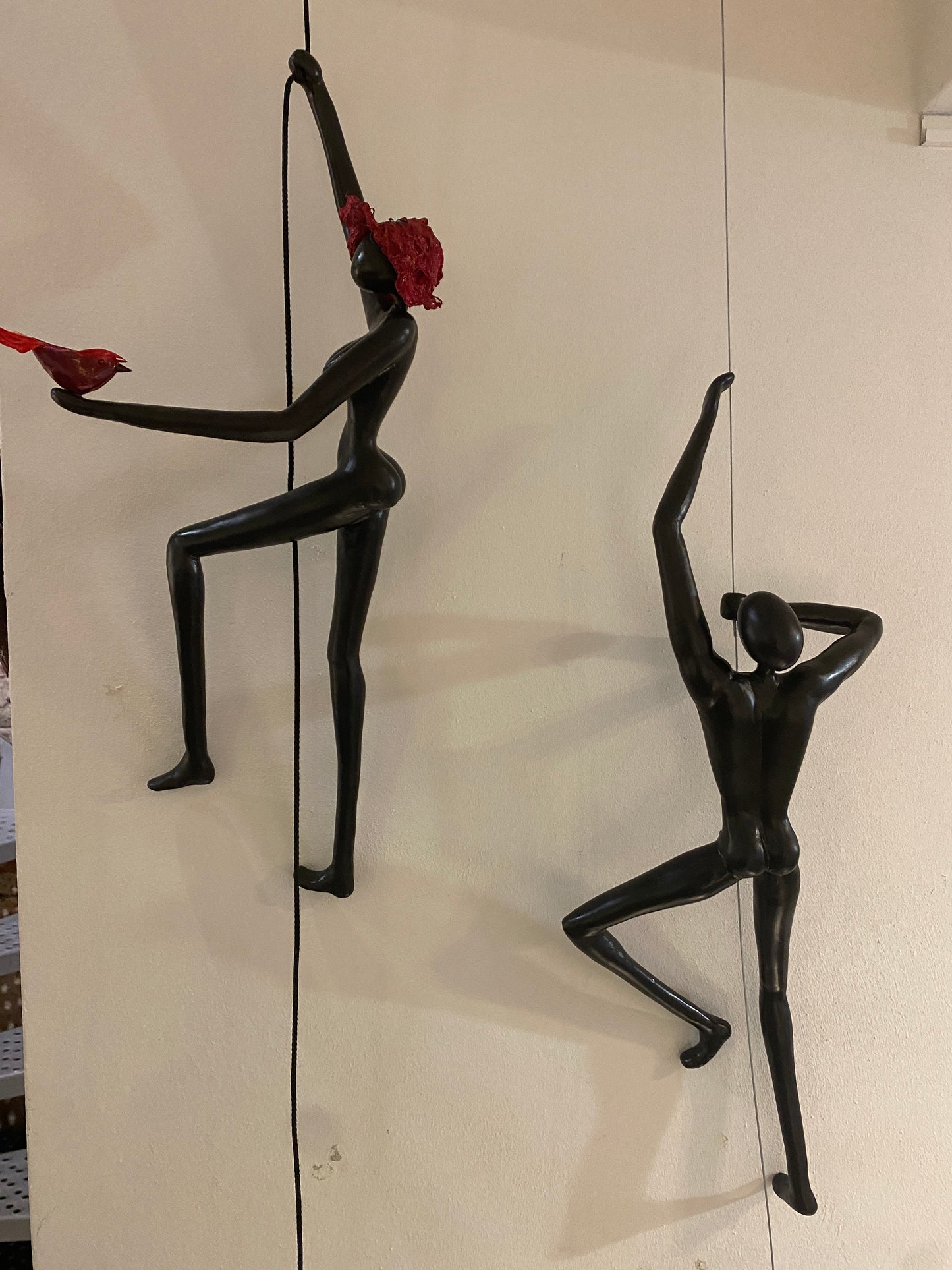 Geveltoeriste met rood hoedje en rood vogeltje aan klimkoord