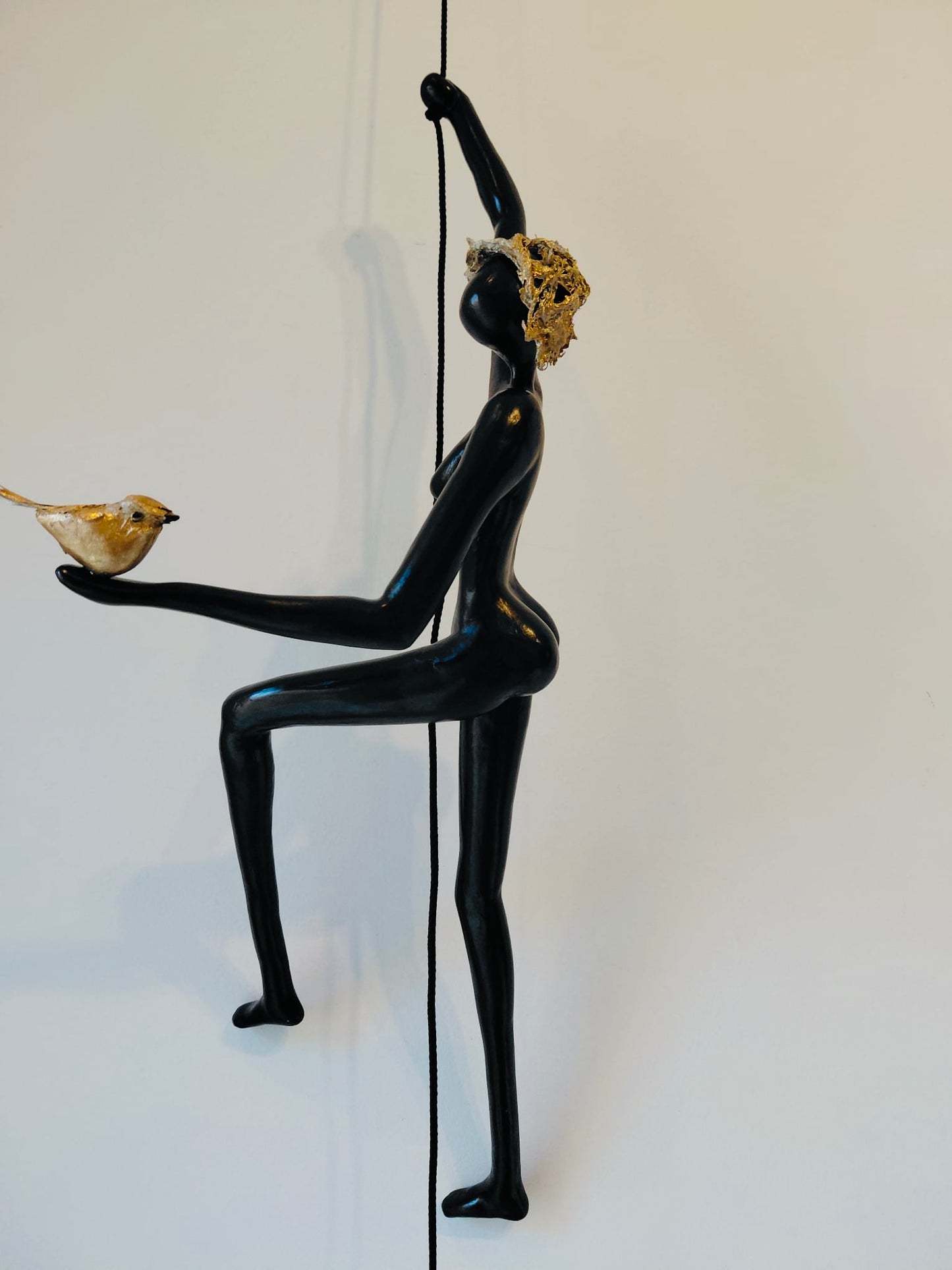 Geveltoeriste met goud hoedje en vogeltje aan klimkoord