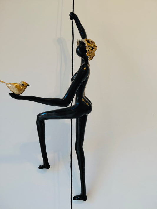 Geveltoeriste met goud hoedje en vogeltje aan klimkoord